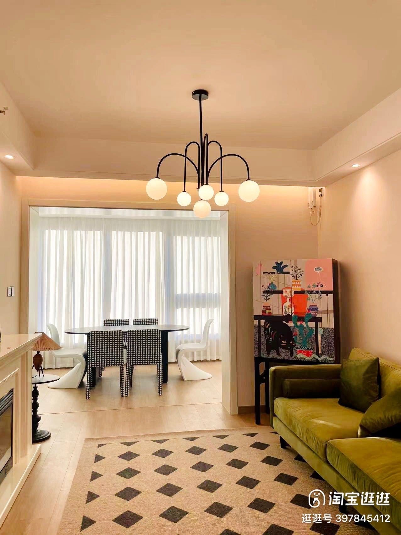 Lustra cu globuri albe mat si structura neagra curbata, montata deasupra mesei de dining intr-un interior colorat