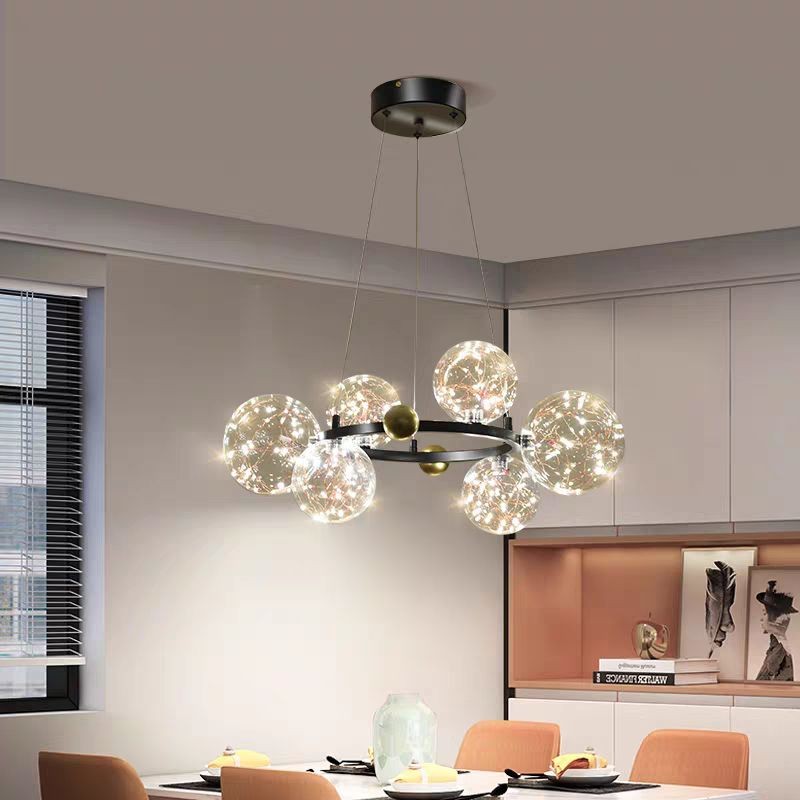 Lustra LED licurici 100W 3000K cu 15 sfere de sticla pe inel metalic negru-auriu, suspendata deasupra mesei de dining