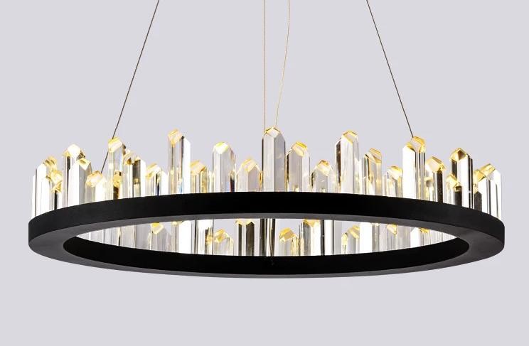 Candelabru LED circular cu cristale fatetate aurii, suspendat pe fond neutru, vedere de ansamblu