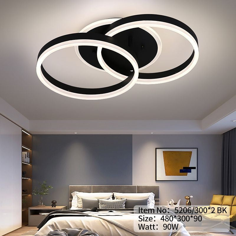 Plafoniera LED neagra cu doua inele suprapuse, iluminand uniform un dormitor spatios