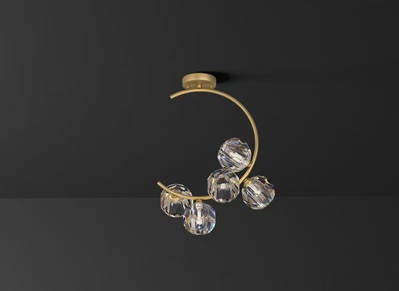 Lustra semiluna cu globuri de cristal fatetate si brat auriu mat, vedere de ansamblu pe fond inchis
