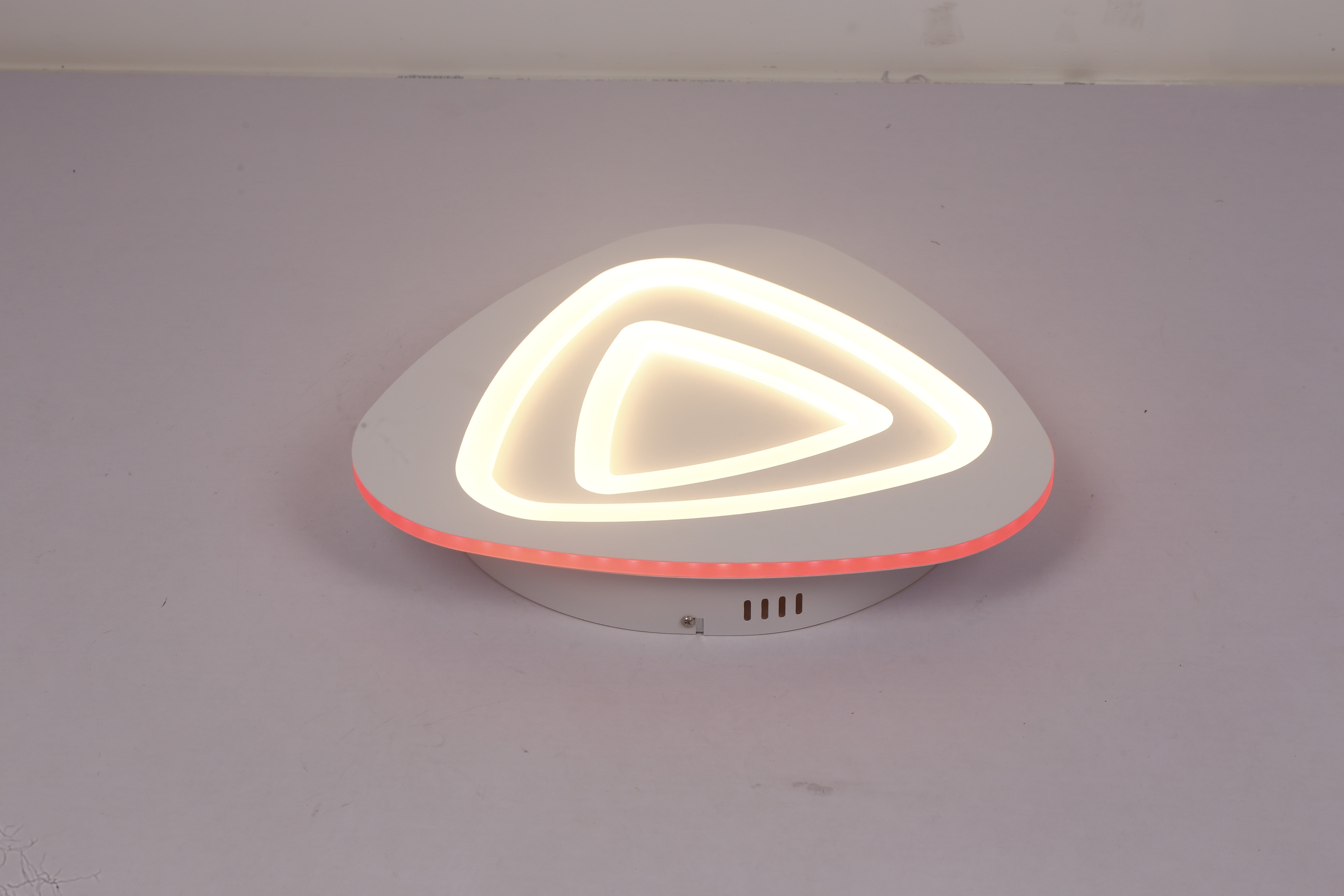 Plafoniera LED triunghi aprinsa cu contur RGB rosu, lumina calda pe straturile acrilice