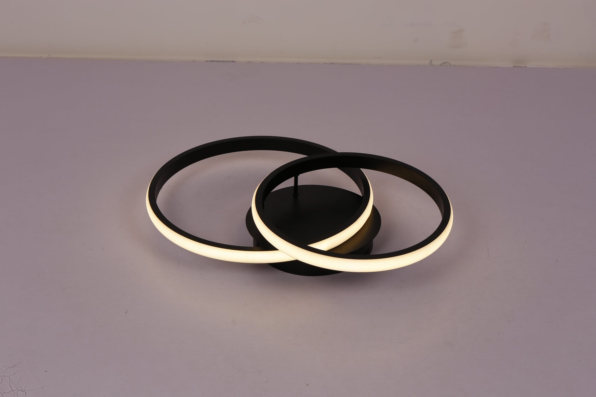 Plafoniera LED doua inele negre aprinsa lumina calda 3000K, vedere laterala pe fond gri