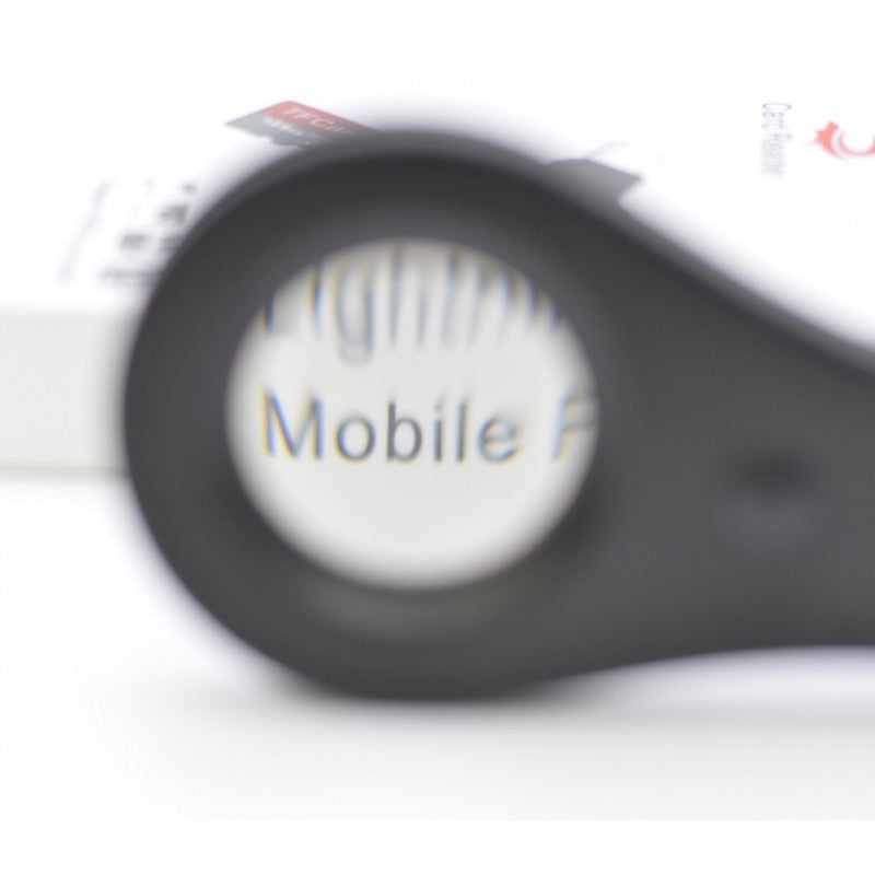 Lupa de mana cu lentila 32mm in actiune, efect de marire optica pe text tiparit