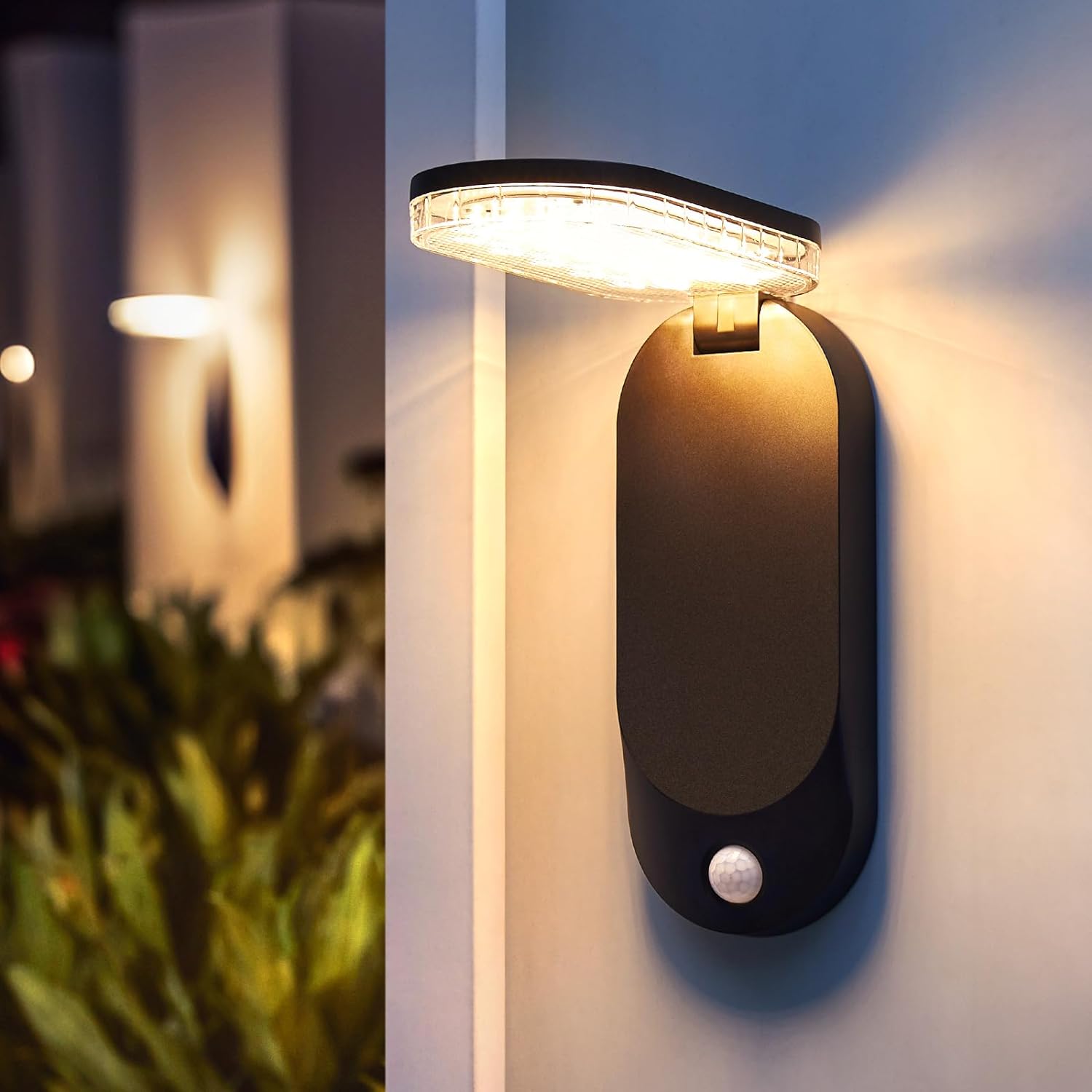 Lampa solara de perete cu senzor PIR montata la intrare, capul pliabil orientat pentru iluminare directa