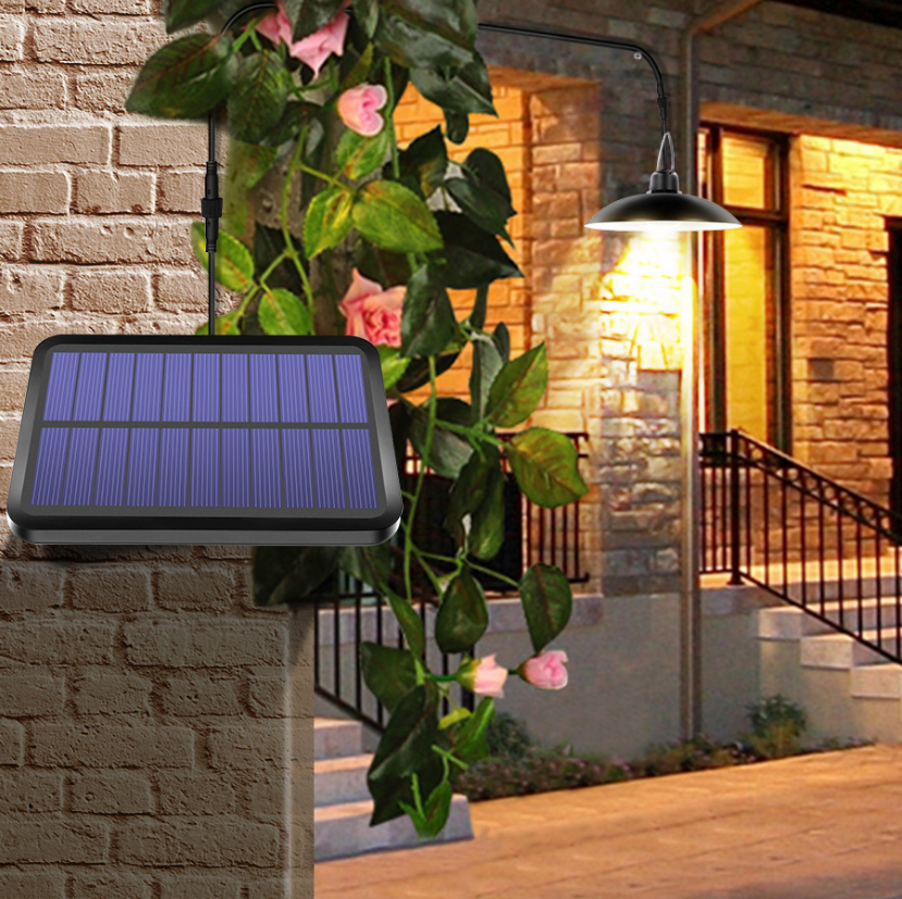 Candelabru solar suspendat iluminand intrarea unei case, panou IP65 fixat pe perete de caramida
