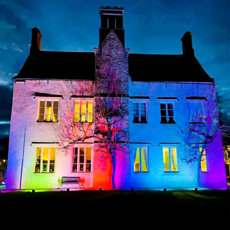 Proiector LED RGB 50W iluminand fatada unei cladiri noaptea in culori multiple, efect decorativ exterior