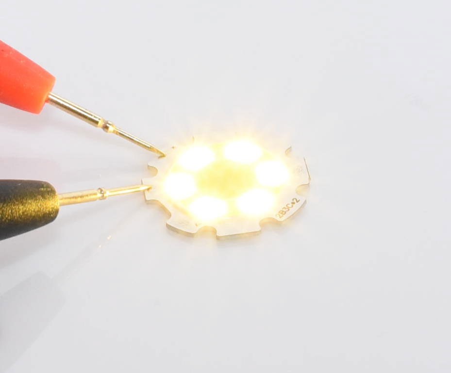 Chip LED COB 28mm in functiune, emisie luminoasa calda vizibila pe suport aluminiu